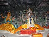 415 Muktinath Jwala Mai Fire Temple Inside Statues Of Manjushri, Avalokiteshvara, Vajrapani The statues in the Jwala Mai fire temple at Muktinath are Manjushri, Avalokiteshvara, and Vajrapani. Padmasambhava is just visible to the left. I kneeled on the floor with my forehead almost touching the ground to see the small 2-inch high blue flame that has been burning here for thousands of years. We now know that this eternal burning flame is actually natural gas. Pilgrims have been coming here for more than 3000 years to witness this natural combination of water, air and fire at one spot.